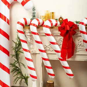 Inflatable red and white striped candy canes hung over a decorated Christmas fireplace