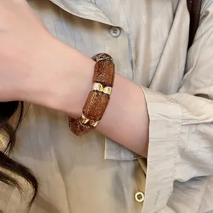 Vintage acrylic geometric bracelet with golden accents on wrist for stylish women
