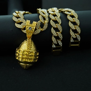 Detailed close-up of golden rugby pendant on iced-out Cuban link chain for hip hop style