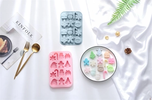 Detailed view of blue and pink silicone Christmas baking molds with festive holiday shapes