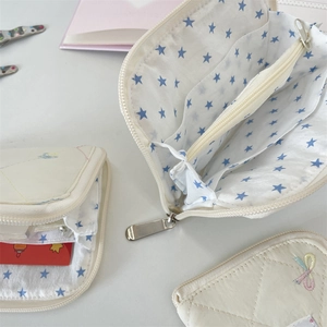 Macro view of quilted wallet with blue star lining and internal storage compartments