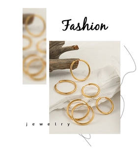 Polished gold hoop earrings in various diameters displayed on a white textured background