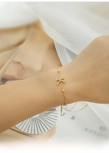 Detailed close-up of a gold-plated titanium steel bracelet featuring a zircon K-letter charm