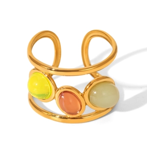 Detailed macro view of wide gold plated hollow ring with three colored gemstones