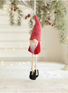 Detail of plush Christmas gnome ornaments with long legs hanging on a festive Xmas tree