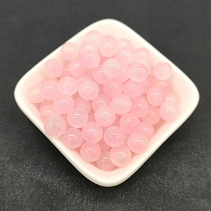 Close-up of 8mm pink gradient glass beads for DIY jewelry making in a white bowl