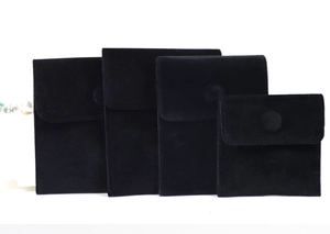 Detail view of black velvet jewelry pouches in four sizes with snap button closure
