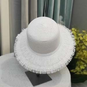 Detail of white woven straw hat with fringed edges on a metal display stand