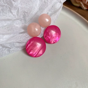 Detail of pink resin earrings featuring marble texture and round geometric design