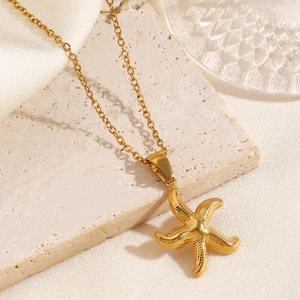 Collier avec pendentif étoile de mer dorée sur pierre beige, style vacances à la plage