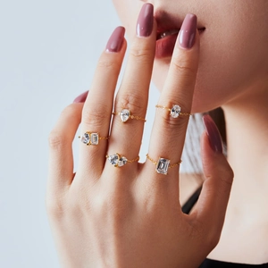 Close-up of five adjustable gold chain rings with pear and oval cubic zirconia stones