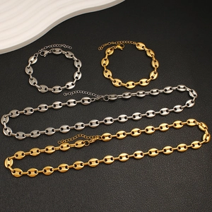 Flat lay of gold and silver coffee bean link necklaces and bracelets in high contrast