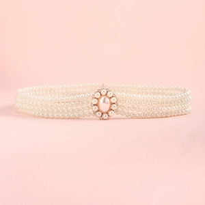 Close-up of pearl waist chain featuring an oval metal clasp with crystals on pink background