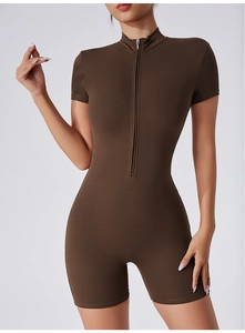 Détail du col montant zippé et de la coupe ajustée du jumpsuit de sport marron