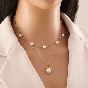 Double layer gold chain necklace with white pearls and teardrop pendant on model