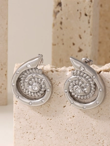 Detail of silver spiral shell earrings with rhinestones on a natural stone base