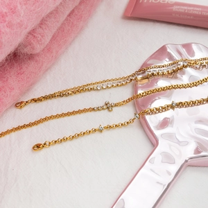 18K gold plated stainless steel bracelet with white zircon and cross detail on white background