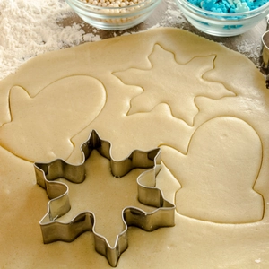 Stainless steel Christmas cookie cutters set with snowflake and glove shapes in dough