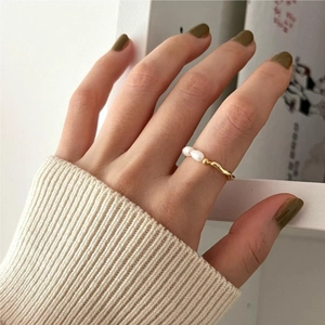 Elegant 925 sterling silver wavy gold ring featuring two white pearls on model's hand
