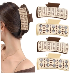 Detail of four geometric faux leather hair claws in dark brown and beige on white background