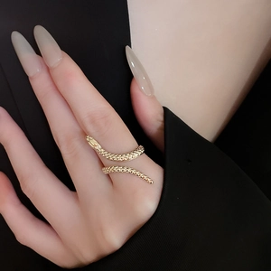 Detailed close-up of a golden snake-shaped adjustable open ring on model's finger