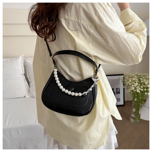 Chic black crescent moon handbag with faux pearl handle shown on a shoulder strap