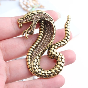 Close-up of vintage bronze cobra brooch with brown rhinestones and detailed scales