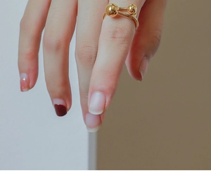 Detail showing the double gold spheres and U-shaped band on the index finger