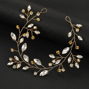 Detail of handmade bridal gold vine hairband with sparkling rhinestones on black background