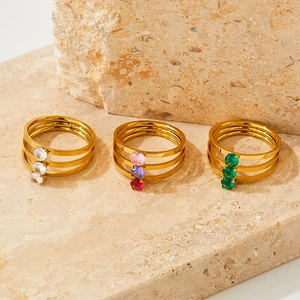Three-piece gold plated stainless steel ring set with zircon stones on sandstone