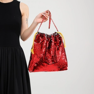 Detail of red sequin bucket bag with metal chain strap and yellow drawstring detail