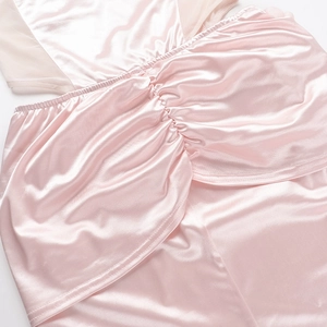 Close-up of pink satin fabric with elegant ruffled details and mesh stitching texture