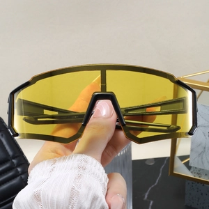 Detail view of large yellow polarized lenses on black semi-rimless cycling sunglasses