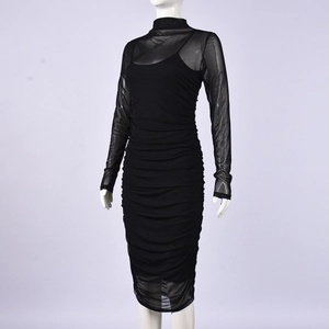 Détail de la robe en maille noire moulante avec texture plissée et manches longues
