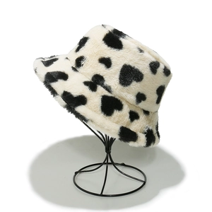 Close-up of plush faux fur bucket hat featuring heart-shaped cow print patterns