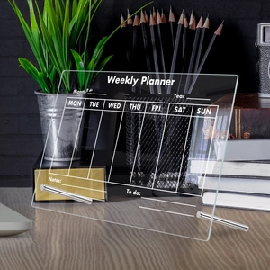 Detailed view of clear acrylic weekly planner board with metal stand for desktop use