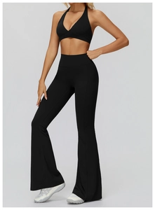 Detail of black halter yoga bra and high waisted flared pants showing fabric texture