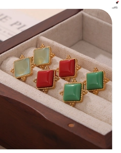 Detailed view of three pairs of vintage square stud earrings in green and red resin