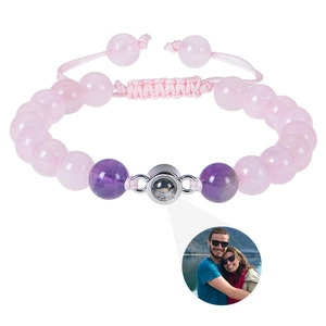 Detail showing pink and purple stone bead bracelet with a silver photo projection charm