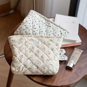 Detailed macro of quilted corduroy makeup bags with heart and floral patterns
