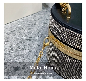 Detail shot of golden metal hardware hook and sparkling silver rhinestones on luxury bag