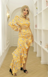Detail of yellow floral dress showing one-shoulder cut, waist cutout and ruffled hemline