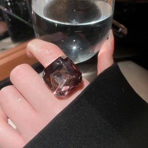 Close-up of a large emerald-cut smoky purple gemstone ring worn on finger