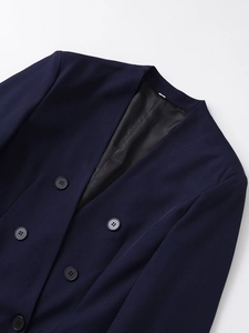 Dettaglio del blazer blu scuro senza colletto con fodera liscia e bottoni pregiati