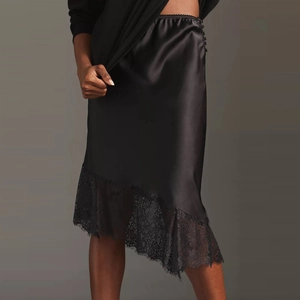 Detail of elegant black satin midi skirt featuring exquisite lace trim at the hemline