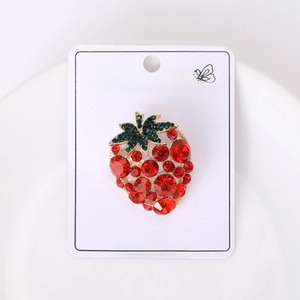 Close-up of strawberry brooch with red and green crystals on gold alloy base