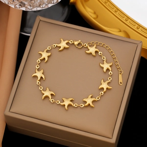 Macro shot of gold starfish linked bracelet on a luxury brown velvet jewelry box