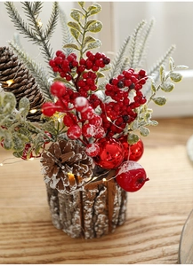 Christmas faux flower pot with red berries, pine cones and warm LED lights in wood base