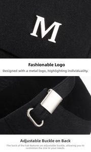 Detail of silver metal M logo and adjustable back buckle on a black canvas baseball cap