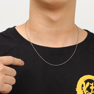 Close-up of a silver stainless steel ball chain necklace worn on a model neck